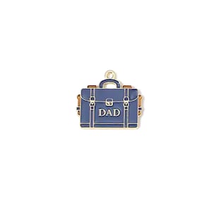 May include: A blue briefcase charm with gold-colored accents and the word "DAD" in white. The charm has a handle and is likely made of metal or enamel. The briefcase design is detailed with clasps and a lock.