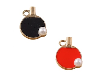 May include: Two gold-coloured table tennis paddle charms with a white pearl. One paddle is black and the other is red.