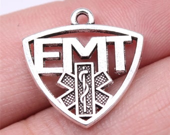May include: Silver charm with the letters EMT and a medical symbol in a triangle shape.