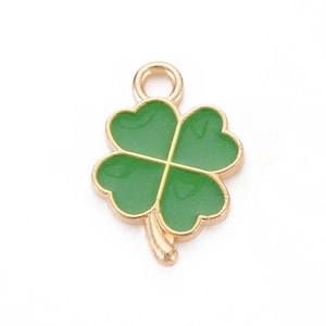 May include: A gold-colored charm in the shape of a four-leaf clover. The clover is green and has a gold-colored loop at the top for attaching to a necklace or bracelet.