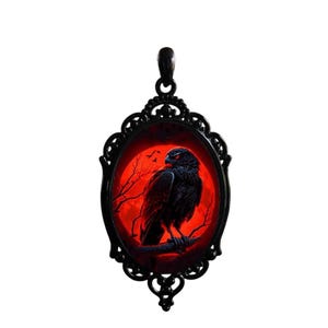 May include: Black oval pendant with a gothic design. The pendant features a black bird perched on a branch against a red background with a full moon and bare tree branches. The pendant has a decorative black frame.