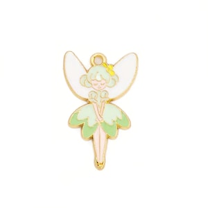 May include: Gold-tone metal charm featuring a fairy with green wings and a white dress. The fairy has a yellow flower in her hair and closed eyes.