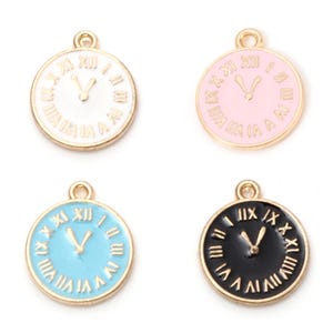 May include: Four gold-colored clock charms with Roman numeral faces. The charms are in four different colors: white, pink, blue, and black.