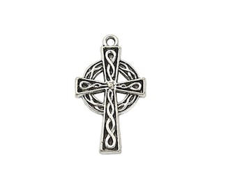 May include: A silver-toned metal pendant shaped as a Celtic cross. The cross features an intricate, raised braided knotwork pattern throughout its surface, set against a darkened, recessed background. A small circular loop is attached at the top.