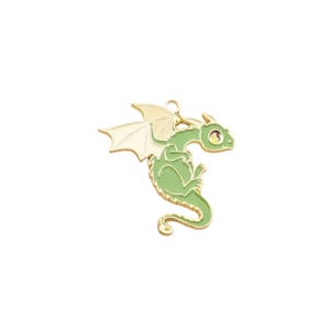 May include: A gold-colored metal charm in the shape of a green dragon with white wings. The dragon has a small, curled tail and large, yellow eyes.