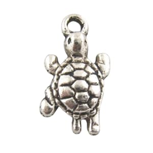 May include: Silver charm in the shape of a turtle with a detailed shell. The charm has a loop at the top for attaching to a necklace or bracelet.