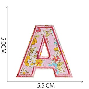 K&ouml;nnte beinhalten: Rosa Stoffbuchstabe A mit Blumenmuster. Der Buchstabe ist 5,5 cm breit und 5,0 cm hoch.