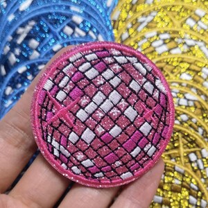 Op de afbeelding: Een ronde, roze en witte glitter discobal-strijkpatch. De patch heeft een glinsterende afwerking.