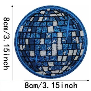 Op de afbeelding: Een blauwe en witte glitter strijk-op patch met een discobal ontwerp. De patch is 8 cm in diameter.