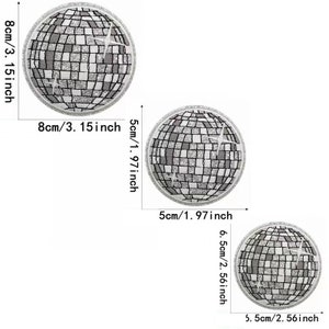 Op de afbeelding: Drie zilveren glitter discobal-strijkpatches in verschillende maten: 8 cm, 5 cm en 6,5 cm.