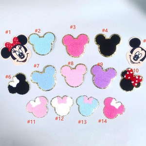 May include: A set of 14 iron-on patches featuring Mickey Mouse and Minnie Mouse in various colors and designs. The patches are perfect for adding a touch of Disney magic to clothing, bags, and other accessories.