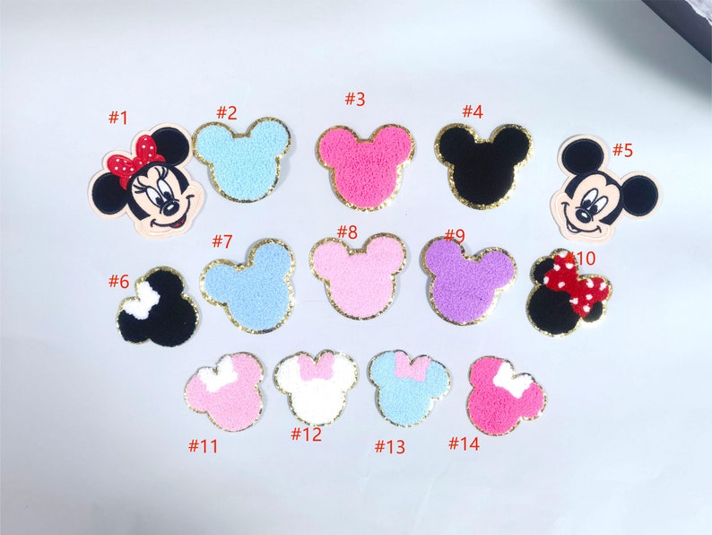 May include: A set of 14 iron-on patches featuring Mickey Mouse and Minnie Mouse in various colors and designs. The patches are perfect for adding a touch of Disney magic to clothing, bags, and other accessories.