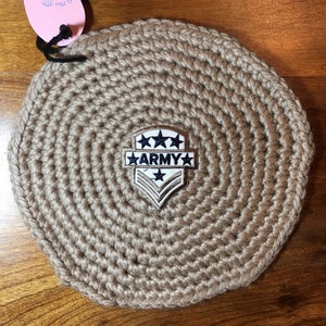 May include: A beige crocheted round coaster with a gold and blue embroidered patch that says "ARMY" with five stars.