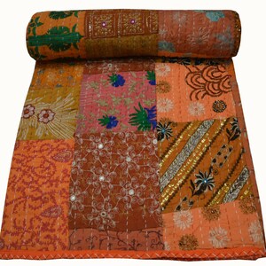 May include: A patchwork quilt with a variety of colors and patterns, including orange, brown, pink, and green. The quilt is made of cotton fabric and is decorated with embroidery and sequins.