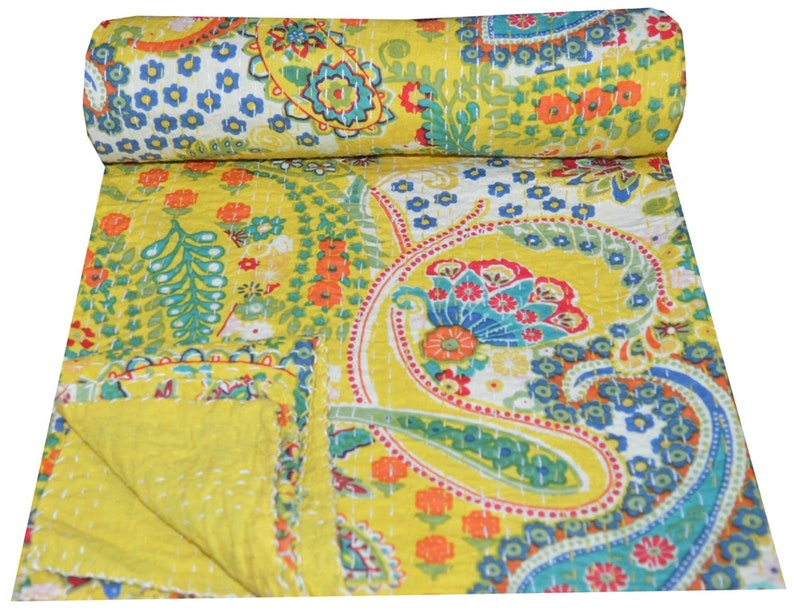 Puede incluir: Una colcha kantha amarilla con un patr&oacute;n de paisley en tonos de azul, verde, rojo y naranja. La colcha est&aacute; cosida a mano y tiene un dise&ntilde;o tradicional indio.