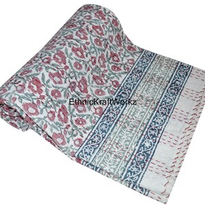 May include: A white cotton quilt with a floral print in shades of pink and green. The quilt has a blue and green border with a floral pattern. The quilt is rolled up and the text "EthnicKraftWorkz" is visible.