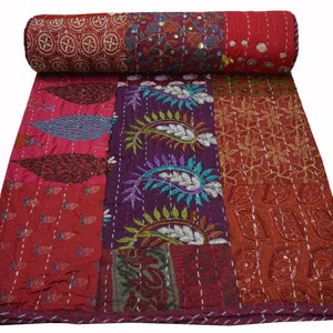 May include: A patchwork quilt with a variety of colors and patterns, including red, purple, and brown. The quilt is made of different fabrics and has a hand-stitched look. It is a traditional Indian kantha quilt.