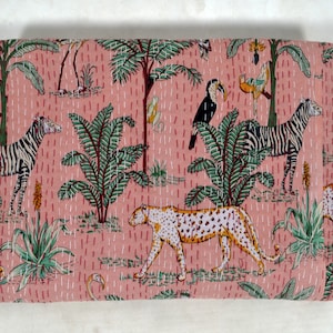 May include: Pink kantha quilt with a jungle animal print. The quilt features zebras, a leopard, toucans, and palm trees.