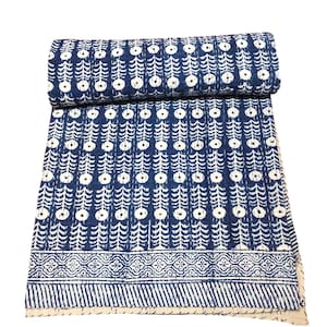 May include: A blue and white kantha quilt with a repeating pattern of circles and leaves. The quilt has a decorative border with a geometric design.