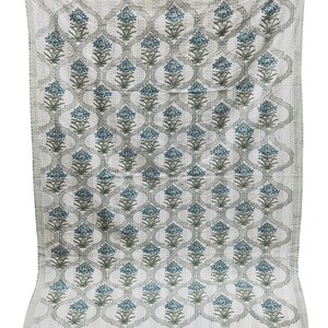 May include: A white cotton quilt with a repeating pattern of blue and green floral designs. The quilt has a traditional Indian style.