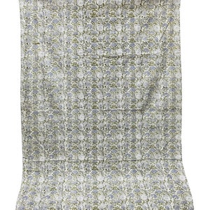 May include: A white cotton quilt with a repeating pattern of green and blue floral designs.