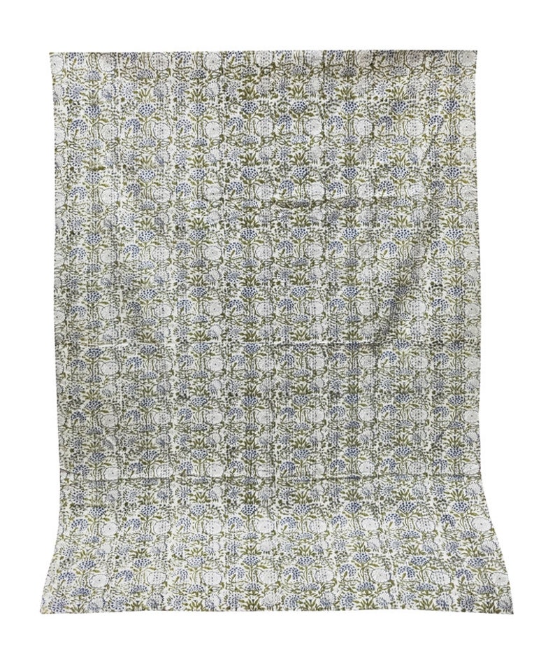 May include: A white cotton quilt with a repeating pattern of green and blue floral designs.