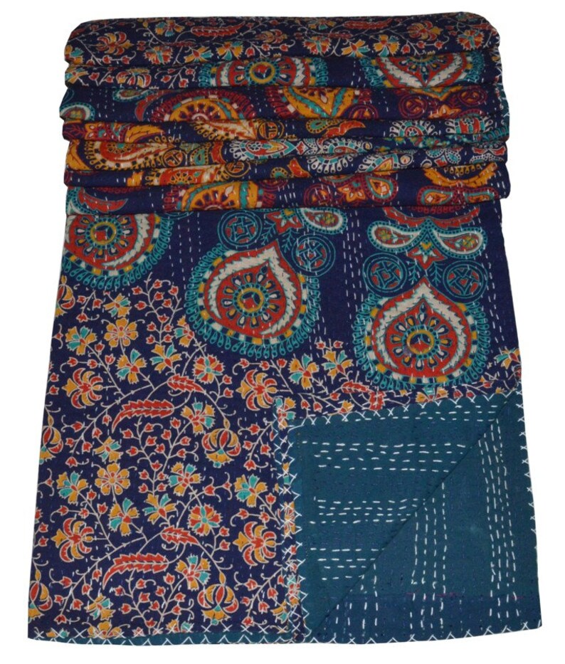 May include: A blue and teal kantha quilt with a paisley and floral pattern. The quilt is folded in half and has a decorative stitch pattern.