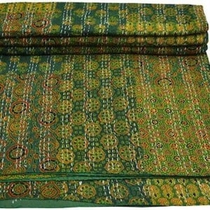 Könnte beinhalten: Eine grüne Kantha-Steppdecke mit floralem Muster. Die Decke ist aus Baumwolle und handgenäht. Es ist ein traditionelles indisches Textil.