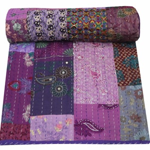 May include: Purple kantha quilt with a patchwork design featuring various floral and paisley patterns. The quilt is made of recycled saris and is hand-stitched with kantha embroidery.