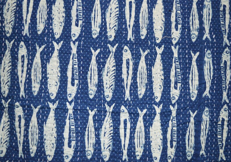 May include: A blue fabric with a white repeating pattern of fish. The fish are all facing the same direction and have a simple design.