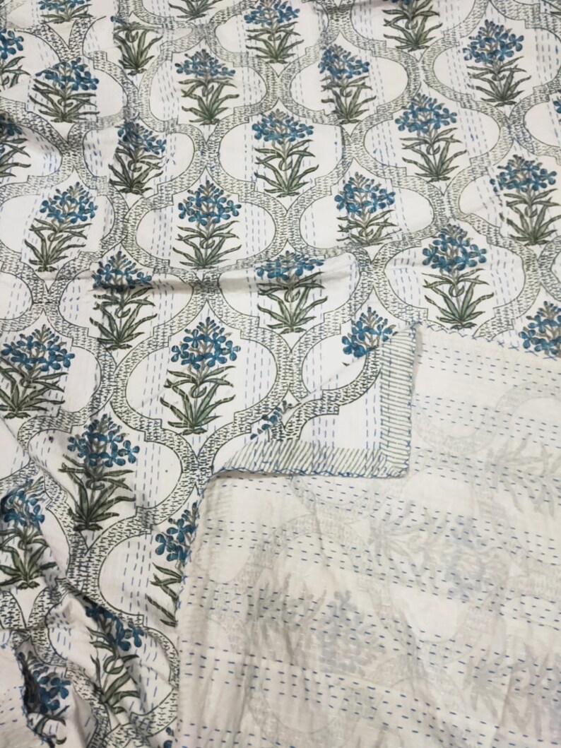 May include: White cotton quilt with a blue and green floral pattern. The quilt is hand-stitched and has a traditional Indian design.