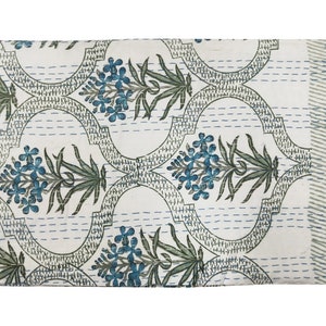 May include: White kantha quilt with a repeating pattern of blue and green floral designs. The quilt is hand-stitched and has a traditional Indian design.