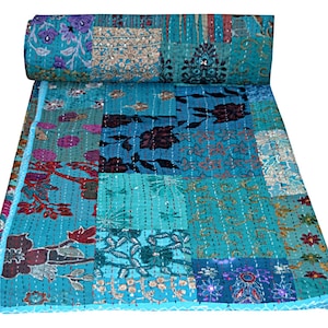 May include: A patchwork quilt with a teal blue background and colorful floral patterns. The quilt is made of various fabrics and is hand-stitched.