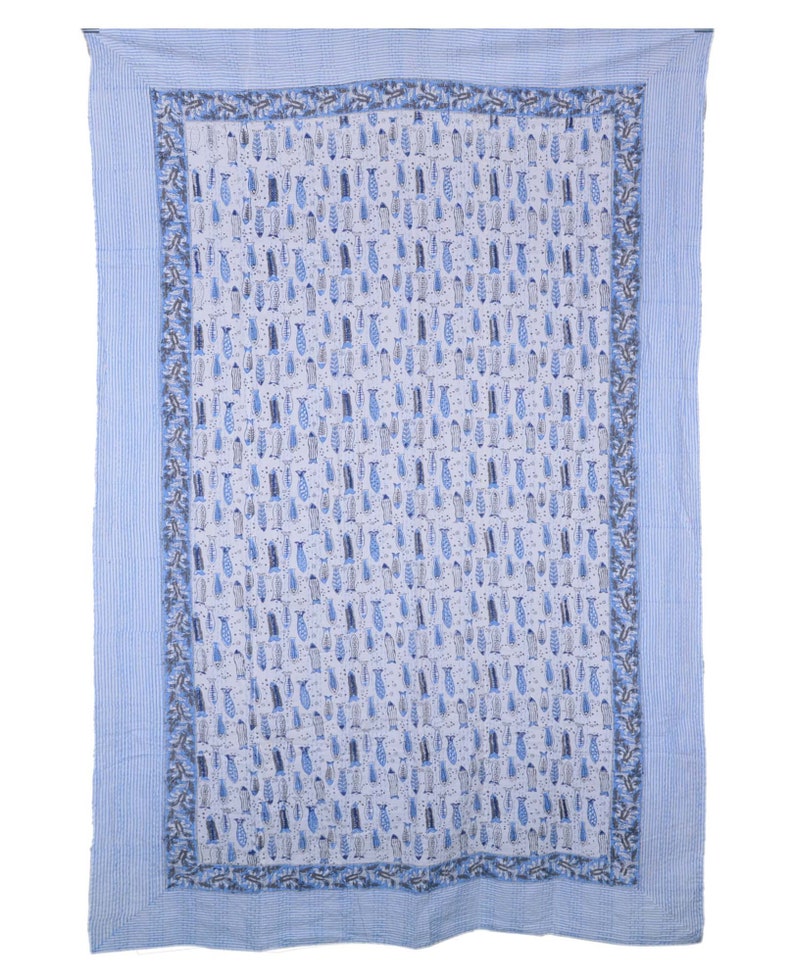 May include: A blue and white cotton quilt with a pattern of small fish. The quilt has a blue border with a white stripe.