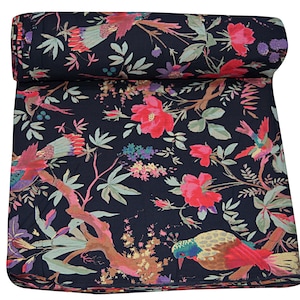 May include: Black fabric with a floral print featuring pink flowers, green leaves, and colorful birds. The fabric is rolled up and has a textured surface.