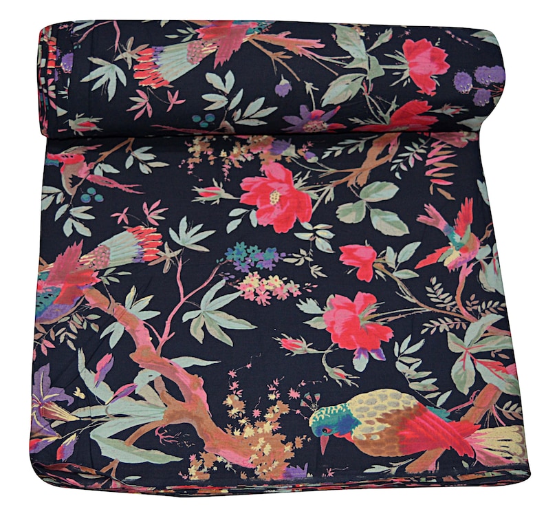 May include: Black fabric with a floral print featuring pink flowers, green leaves, and colorful birds. The fabric is rolled up and has a textured surface.