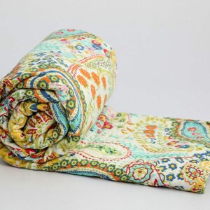 Puede incluir: Una colcha enrollada con estampado paisley en tonos verdes, azules, amarillos, naranjas y rojos. La colcha est&aacute; hecha de algod&oacute;n y es perfecta para a&ntilde;adir un toque de estilo bohemio a cualquier habitaci&oacute;n.