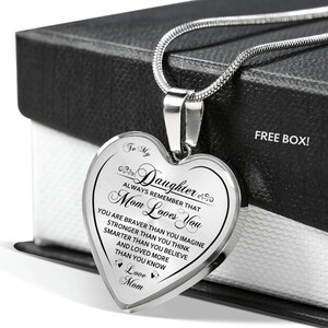 Pode incluir: Um colar de prata em forma de cora&ccedil;&atilde;o com uma mensagem para uma filha de sua m&atilde;e. A mensagem diz: "To My Daughter Always Remember That Mom Loves You You Are Braver Than You Imagine Stronger Than You Think Smarter Than You Believe And Loved More Than You Know Love Mom".