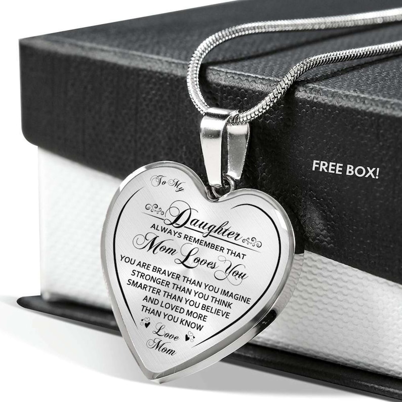 Pode incluir: Um colar de prata em forma de cora&ccedil;&atilde;o com uma mensagem para uma filha de sua m&atilde;e. A mensagem diz: "To My Daughter Always Remember That Mom Loves You You Are Braver Than You Imagine Stronger Than You Think Smarter Than You Believe And Loved More Than You Know Love Mom".