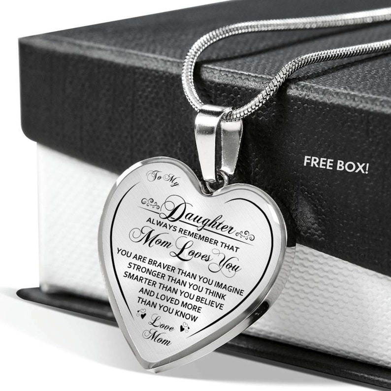 Pode incluir: Um colar de prata em forma de cora&ccedil;&atilde;o com uma mensagem para uma filha de sua m&atilde;e. A mensagem diz: "To My Daughter Always Remember That Mom Loves You You Are Braver Than You Imagine Stronger Than You Think Smarter Than You Believe And Loved More Than You Know Love Mom".