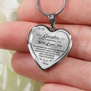 Pode incluir: Colar de prata em forma de cora&ccedil;&atilde;o com uma mensagem que diz "To My Daughter Always Remember That Mom Loves You You Are Braver Than You Imagine Stronger Than You Think Smarter Than You Believe And Loved More Than You Know Love Mom"