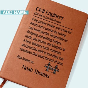 May include: A brown leatherette notebook with the text "Civil Engineer" and a definition. The notebook includes the name "Noah Thomas" and a bridge graphic. A ribbon bookmark is visible.