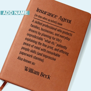 May include: A brown leather-bound notebook with the text "Insurance Agent" and a definition. The notebook includes the name "William Beck" at the bottom. A bookmark is visible.