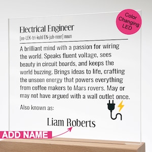 May include: Clear acrylic sign with the definition of "Electrical Engineer" printed in black. The sign includes a color-changing LED and a wooden base. The name "Liam Roberts" is printed below the definition.
