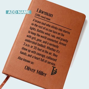 May include: A brown leather-bound notebook with the definition of "Lineman" printed in black. The text describes a brave individual who works to keep the world connected. The notebook includes the name "Oliver Miller" and a small graphic.