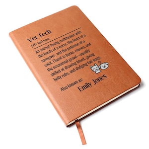 May include: A brown leather-bound notebook with the text "Vet Tech" and a definition. The definition describes a vet tech as an animal-loving multitasker. The notebook also includes the name "Emily Jones" and a ribbon bookmark.