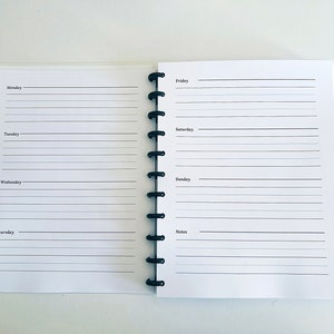 May include: A white planner with a black coil binding. The planner has a weekly layout with spaces for Monday through Sunday, as well as a notes section.