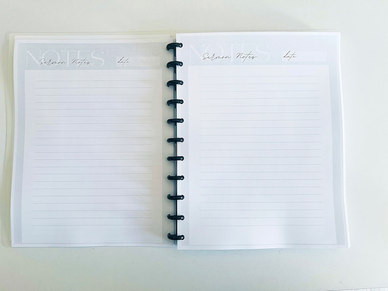 May include: A white notebook with a black spiral binding. The cover has the text "NOTES" and "Sermon Notes" with a space for the date.