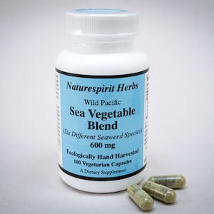 May include: A white bottle of "Naturespirit Herbs" Sea Vegetable Blend capsules. The label is light blue with black text. The bottle contains 100 vegetarian capsules, each with 600 mg of a blend of six different seaweed species. Three capsules are visible next to the bottle.