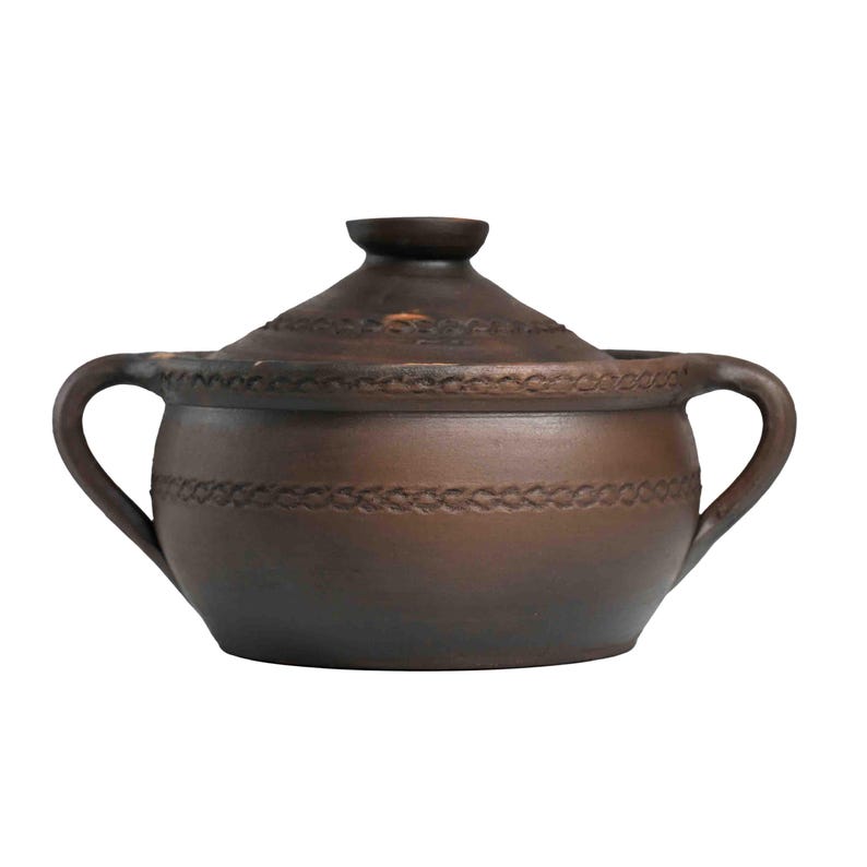 May include: A brown ceramic pot with a lid and two handles. The pot has a decorative design around the rim.